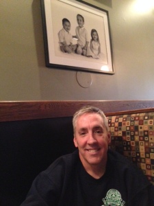 Patrick Ryan, owner of Gov Stumpy's. Sitting beneath a picture of his kids!